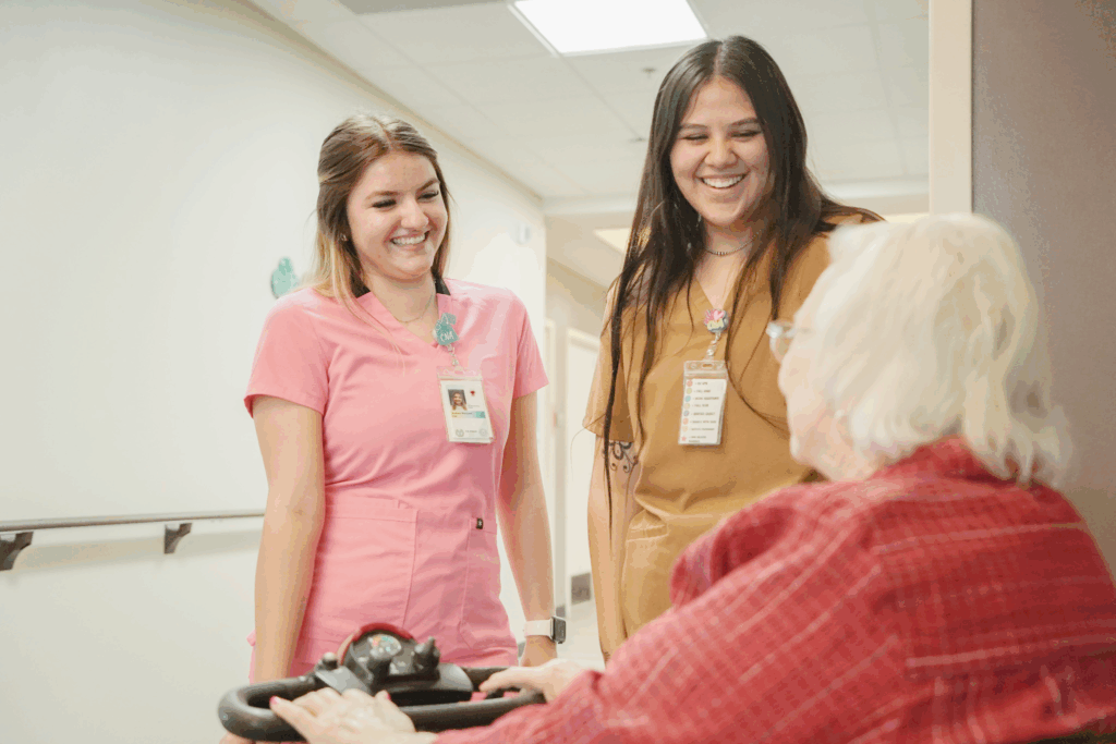 staff talking with a senior patient in a hallway