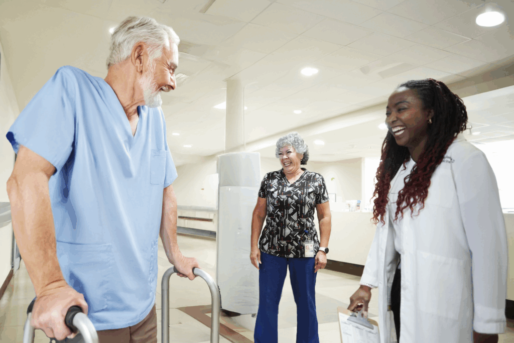 Image of senior patient undergoing physical therapy and laughing with a provider